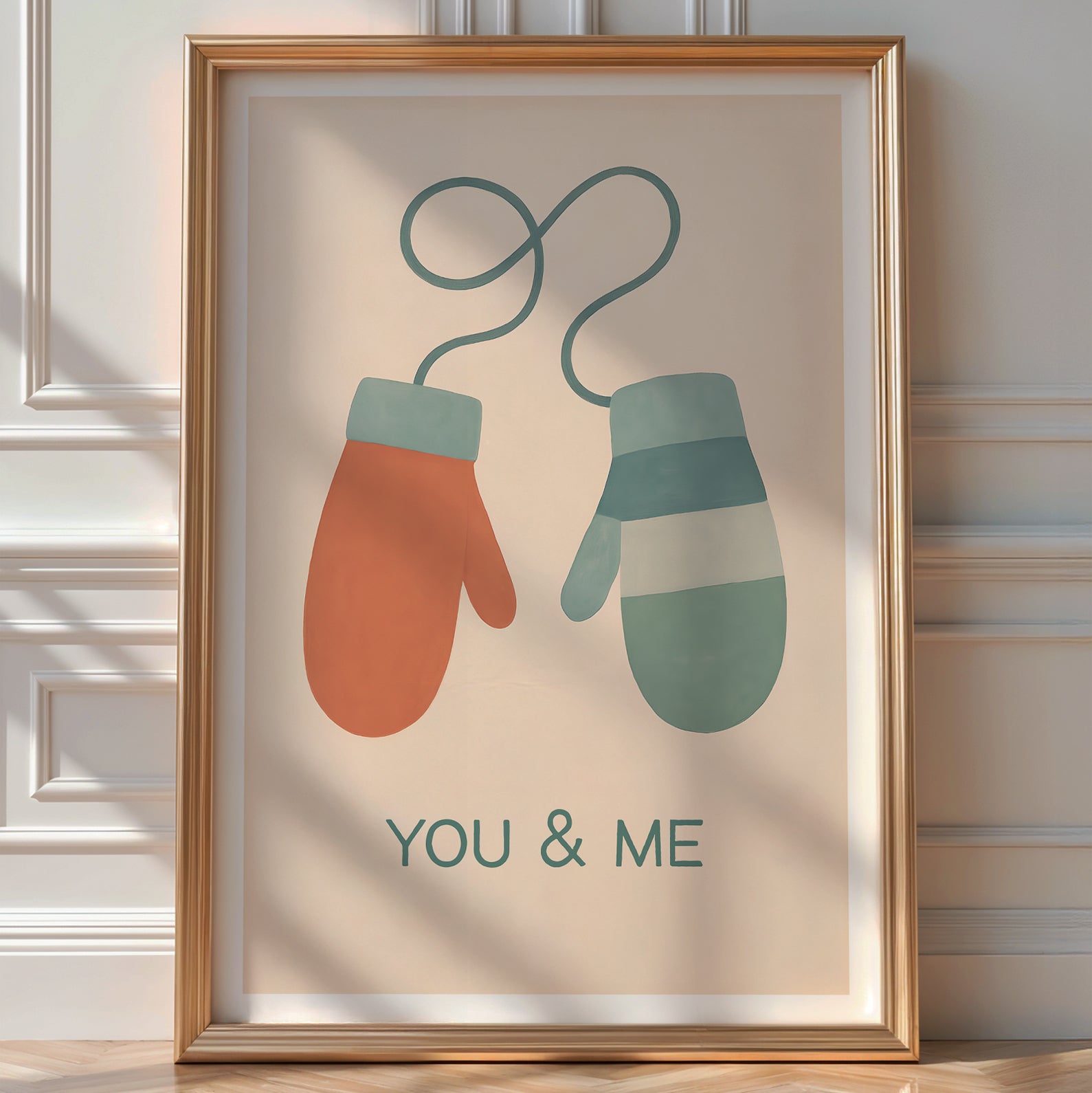 Illustrated 'You & Me' print of two paired mittens, terracotta and sage green, joined by a heart-shaped string