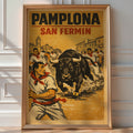 Vintage 'Pamplona San Fermín' poster of runners fleeing a charging bull through the streets