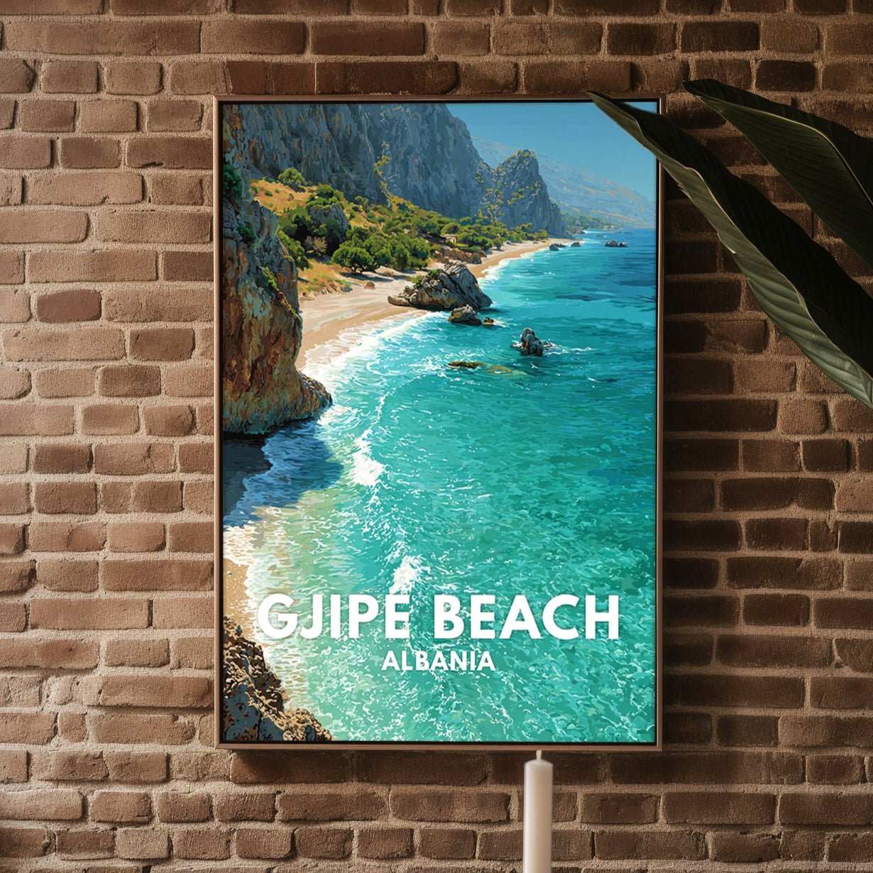 Framed picture of Guje Beach Albania on a brick wall above a white ottoman.