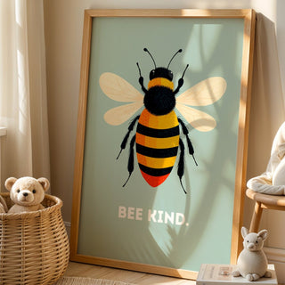 Framed artwork of a bee with 'BEE KIND' text in a room with a teddy bear and basket.