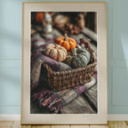Framed photograph of pumpkins and a basket on a wooden surface with a light blue wall background.