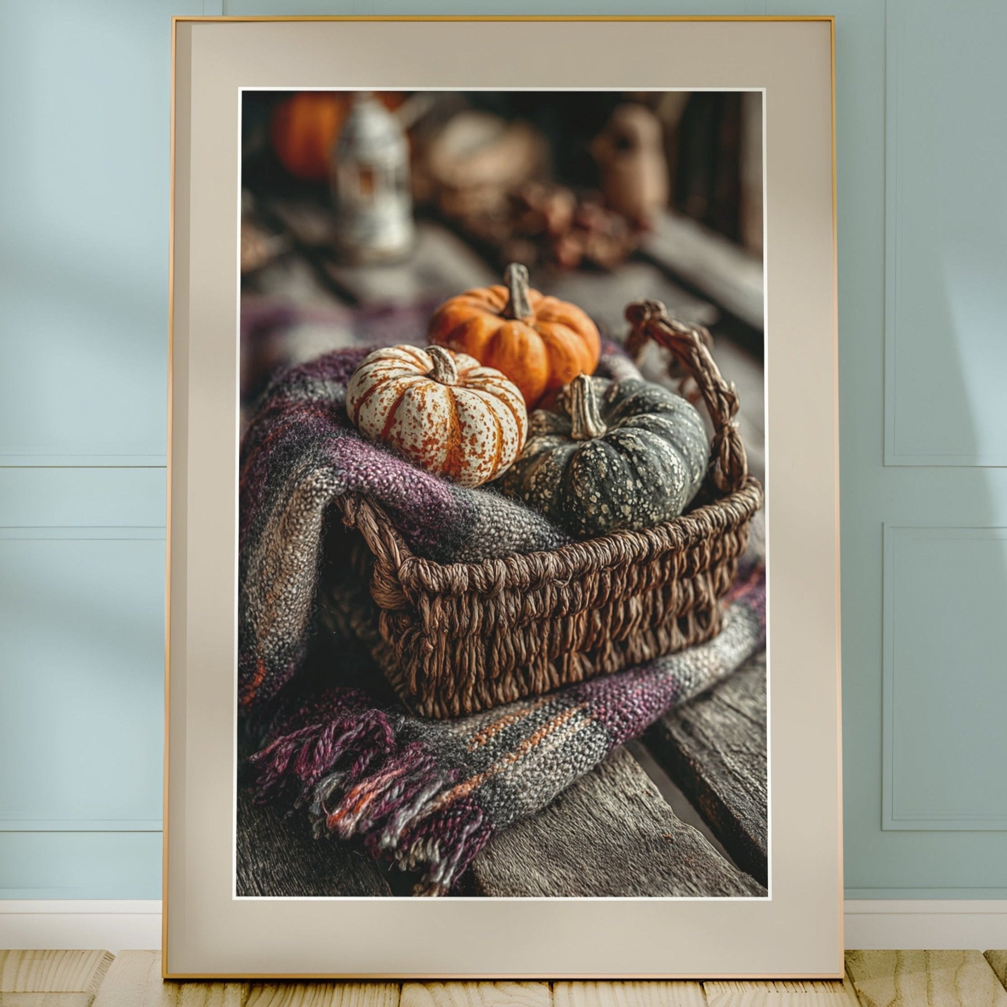 Framed photograph of pumpkins and a basket on a wooden surface with a light blue wall background.