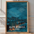 Illustrated 'Alpe d'Huez France' poster of a lit ski village nestled beneath snowy peaks at dusk